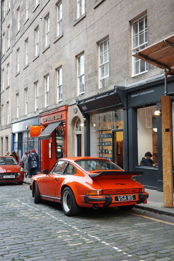 City: Orange sports car on cobbled street