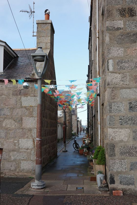 Footdee: Narrow stone passage with bunting