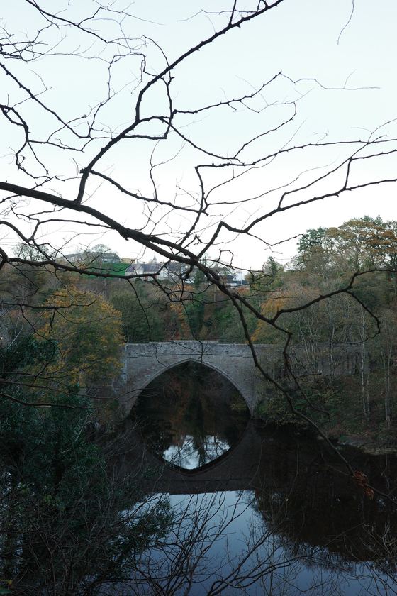 Beach: Stone bridge reflected in dark water