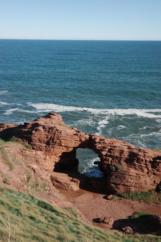 Coastal Walk: Natural arch in red coastal rock