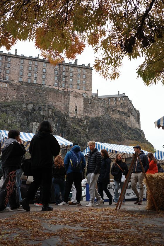 Market: Market stalls beneath castle and autumn leaves