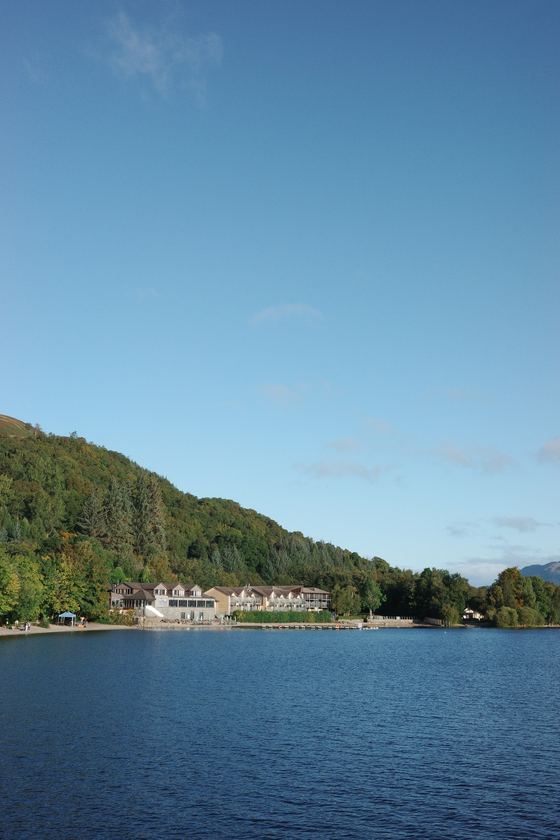 Luss: Wooded shore across blue water