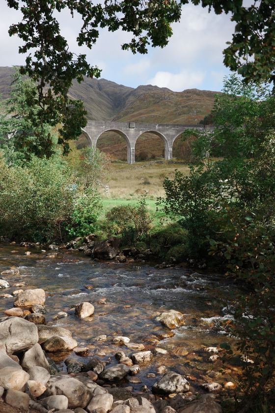 Glenfinnan Viaduct: Viaduct beyond tree-framed rocky stream