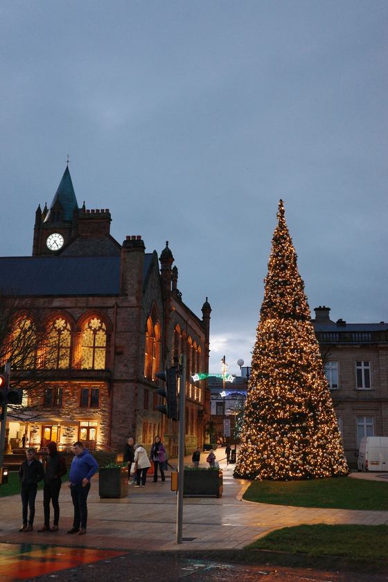 Derry: Christmas tree beside illuminated Guildhall