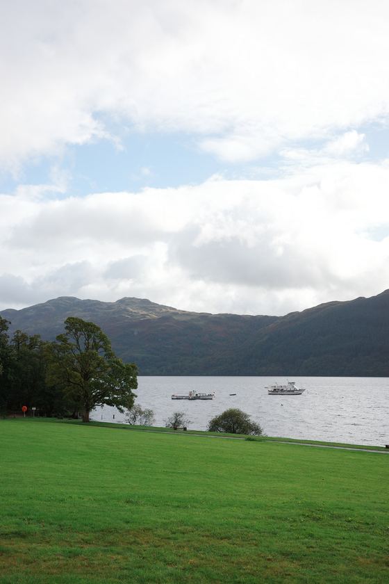 Rest and Be Thankful and Tarbet: Loch and boats beyond green lawn