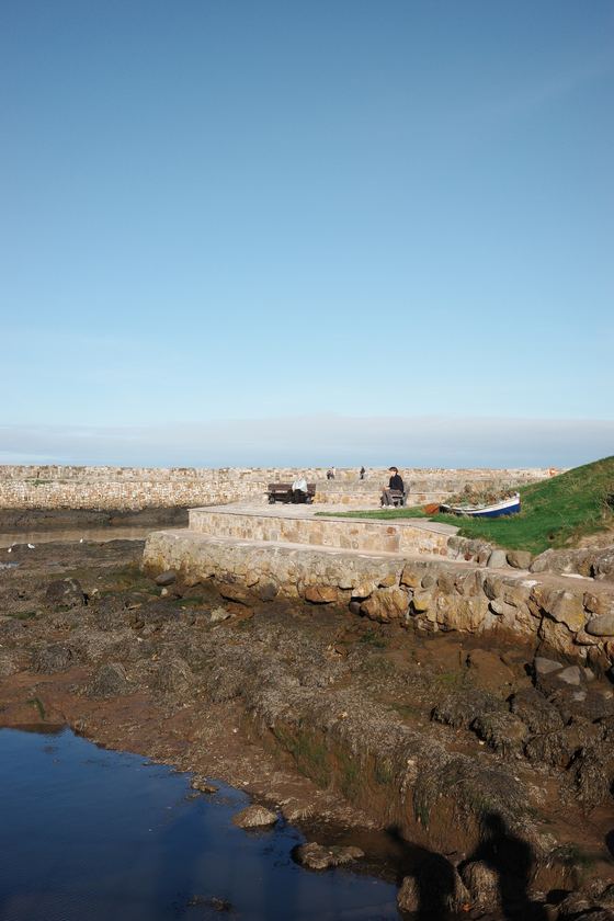 Beach: Rock-lined inlet beneath a clear sky