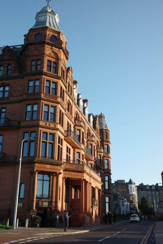City: Sunlit corner building against blue sky