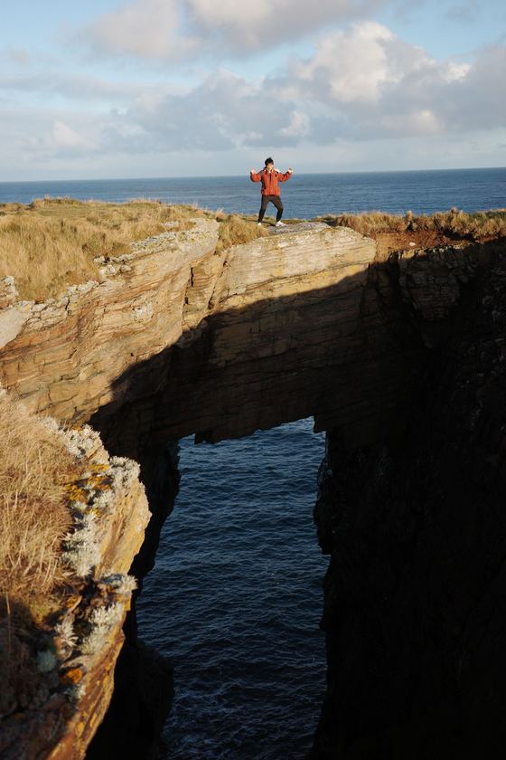 Wick: Walker above dramatic coastal arch