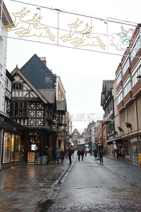 Shrewsbury and Church Stretton: Rainy timbered street beneath holiday lights